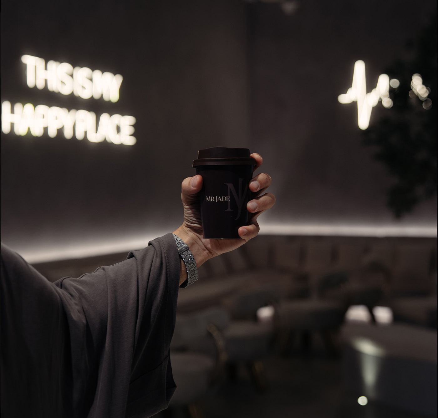 MRJADE flagship interior — lounge seating beneath an olive tree