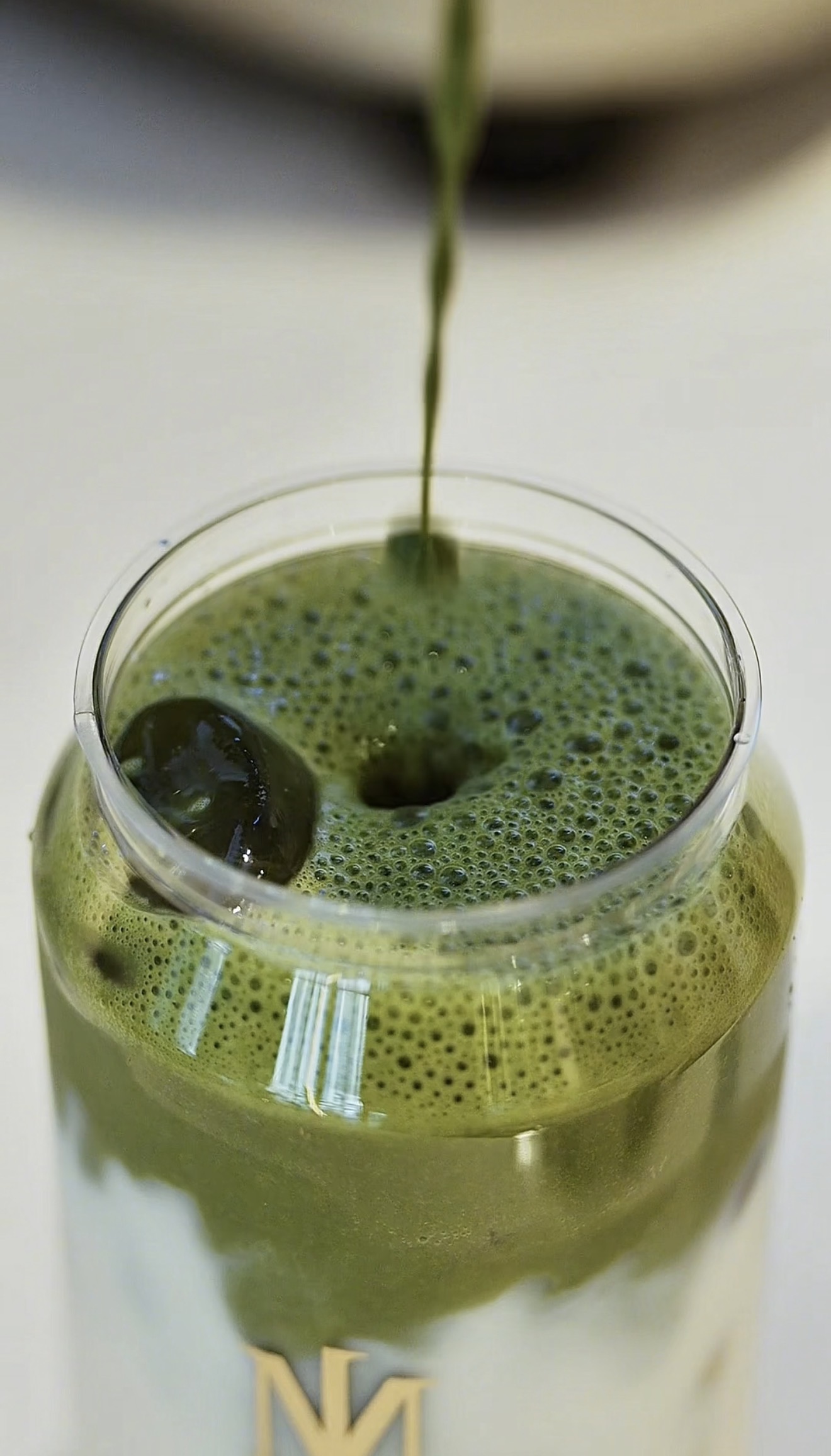 MRJADE matcha being poured into a branded cup